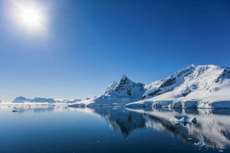El sol brilla sobre un paisaje nevado en la Antártida.